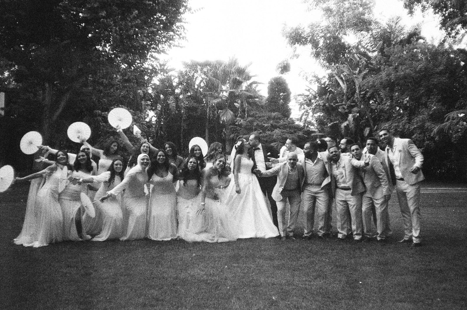 Wedding party gathered together on a lawn, black and white