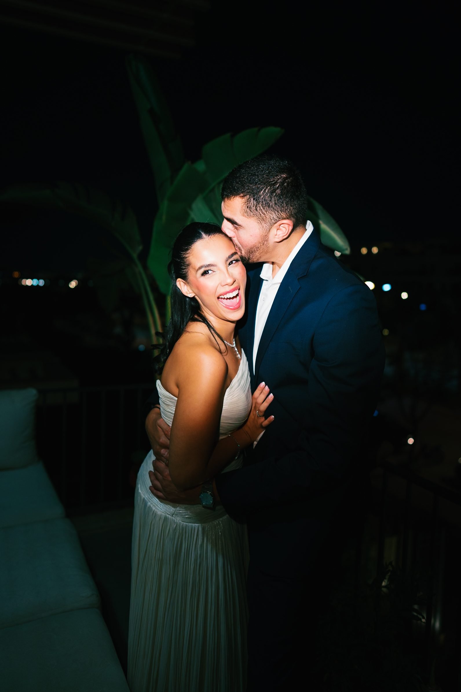 Couple kissing on a terrace at night