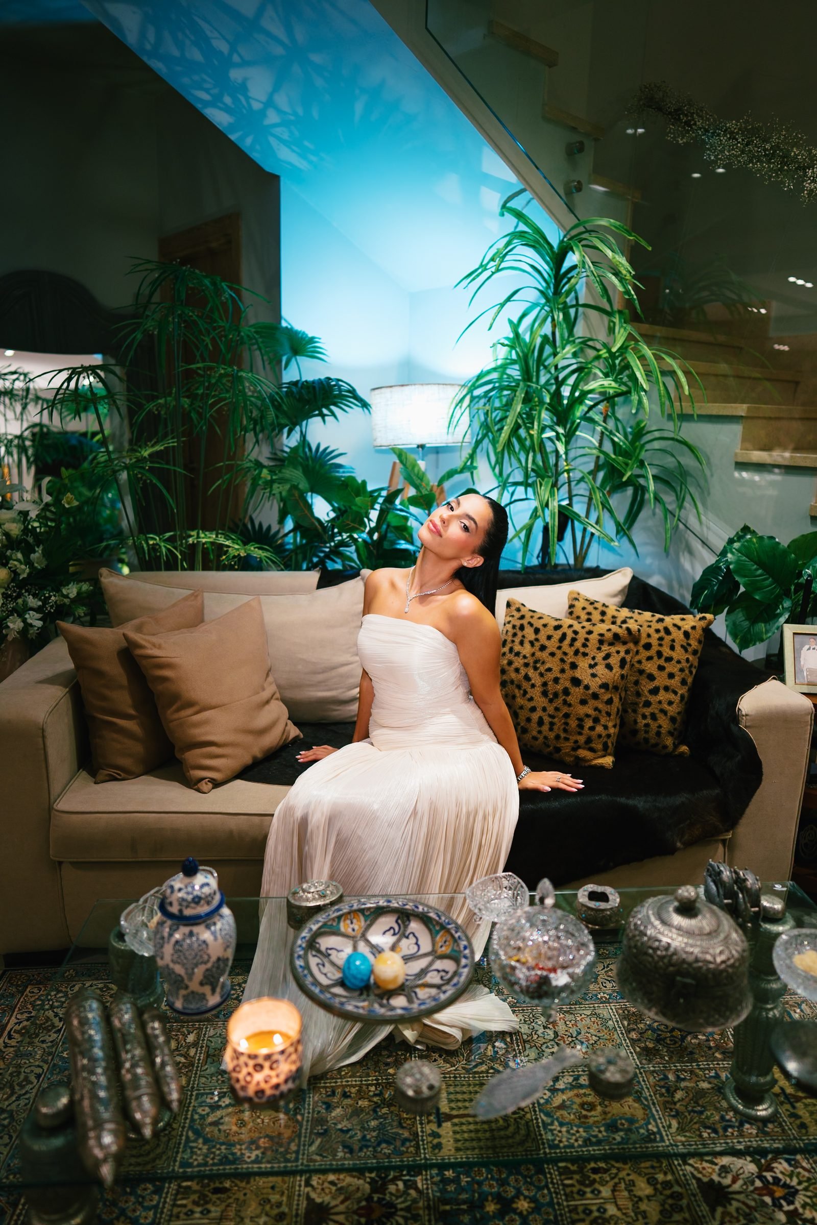 Bride seated on a lounge sofa among plants