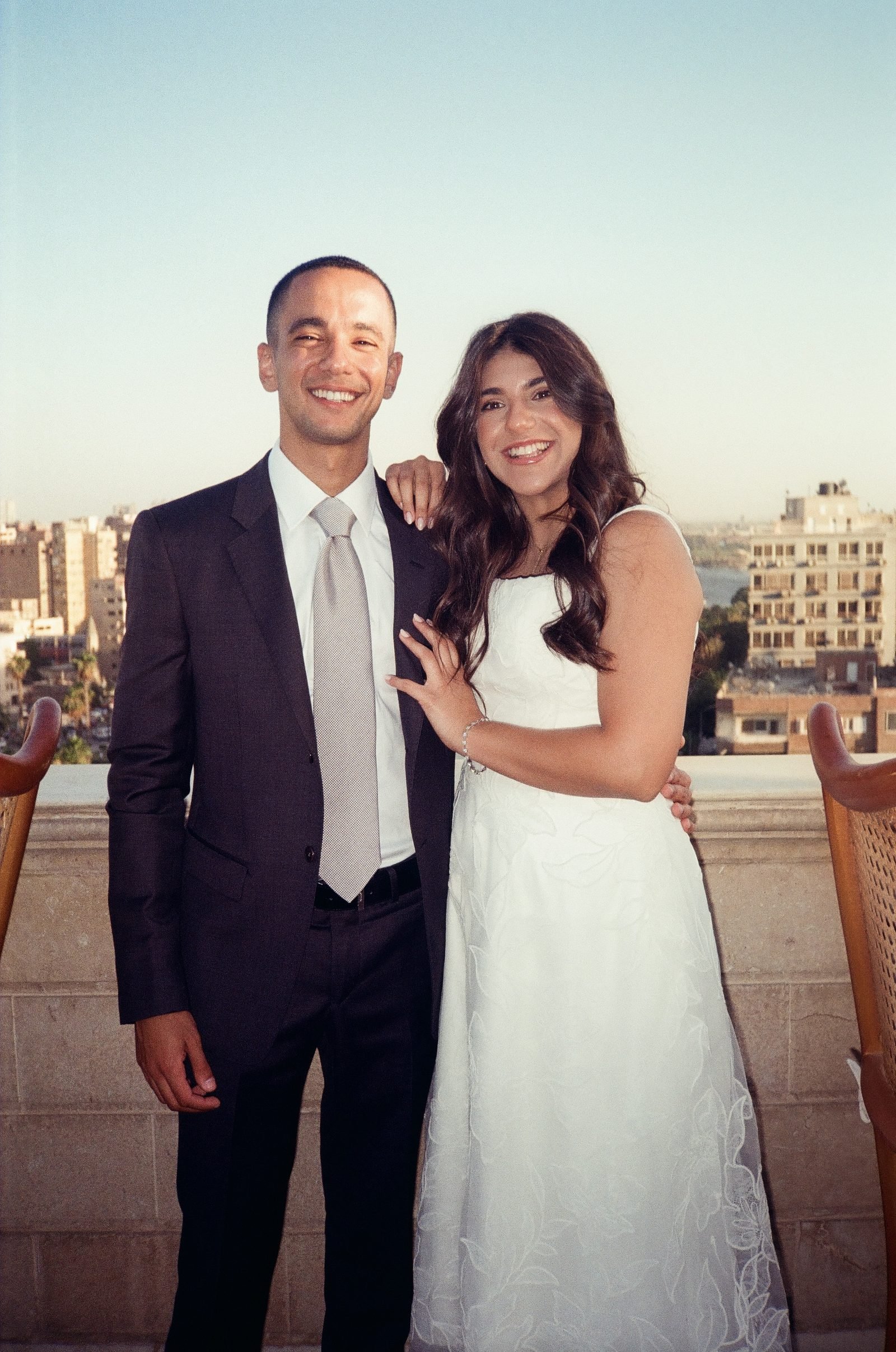 Couple smiling together on a rooftop at dusk