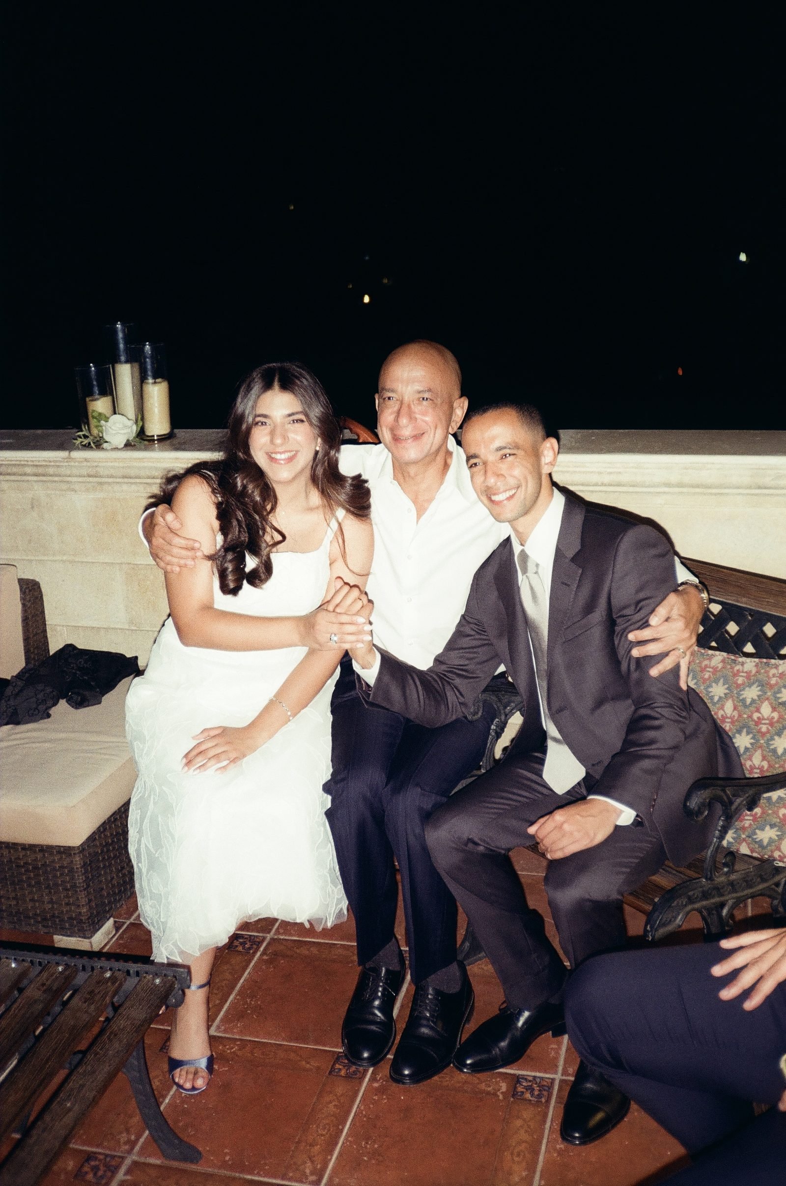 Couple seated with friends on a terrace at night