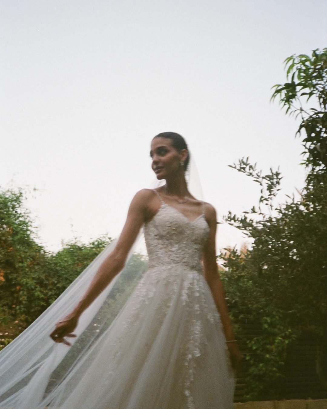 Bride in a flowing veil outdoors at golden hour