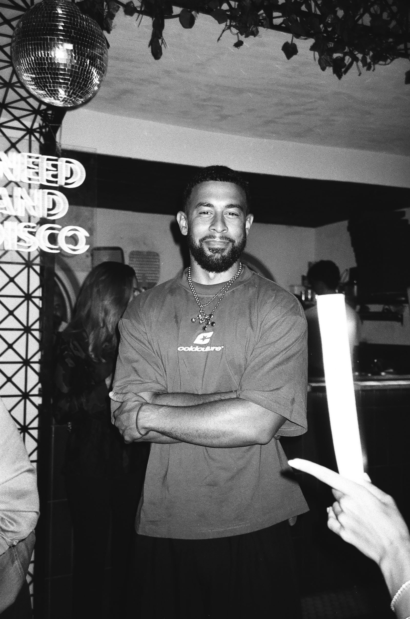 Man smiling with folded arms at the party, black and white