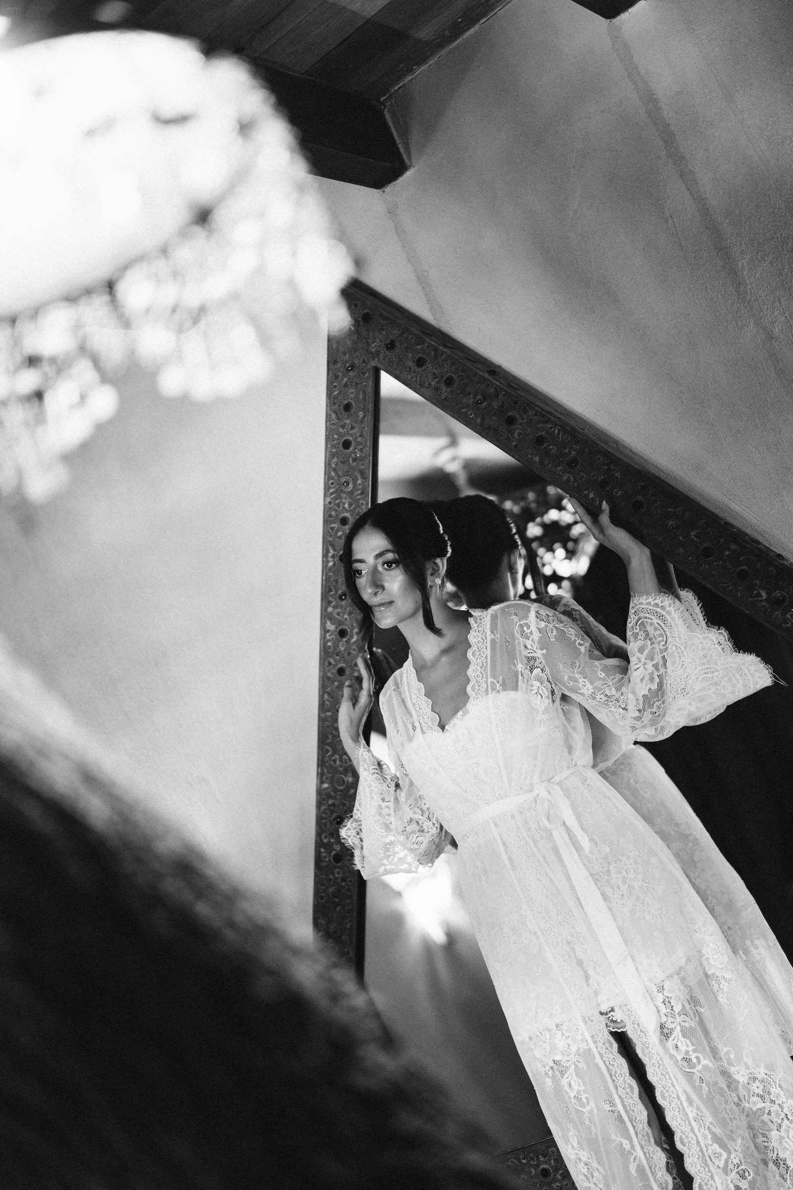 Bride in a lace robe reflected in a mirror, black and white