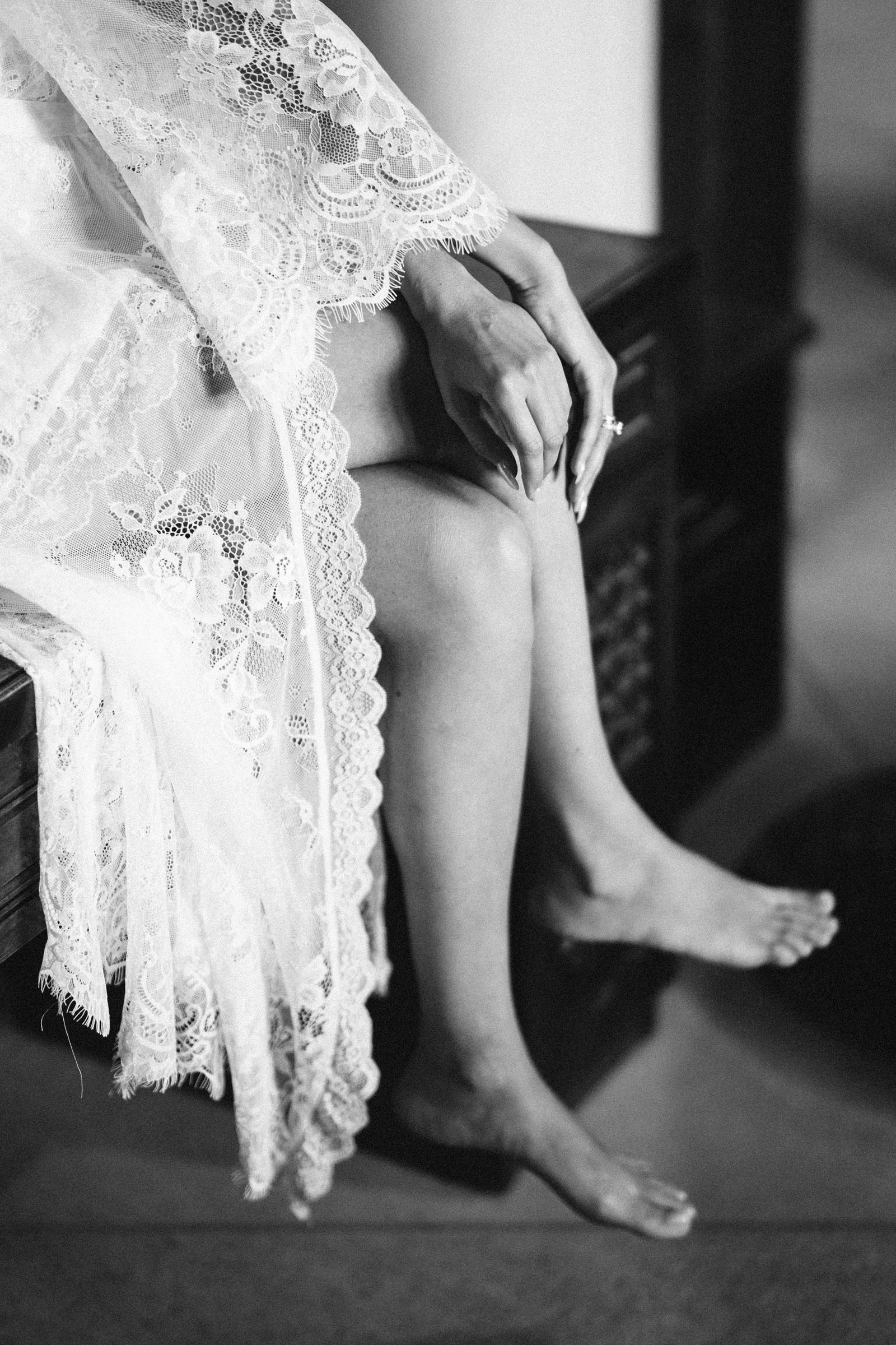 Bare feet and the hem of a lace robe, black and white