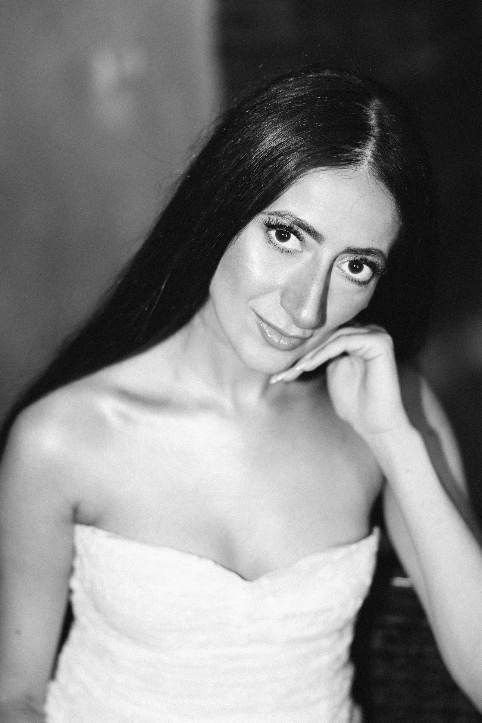 Bride resting her chin on her hand, black and white